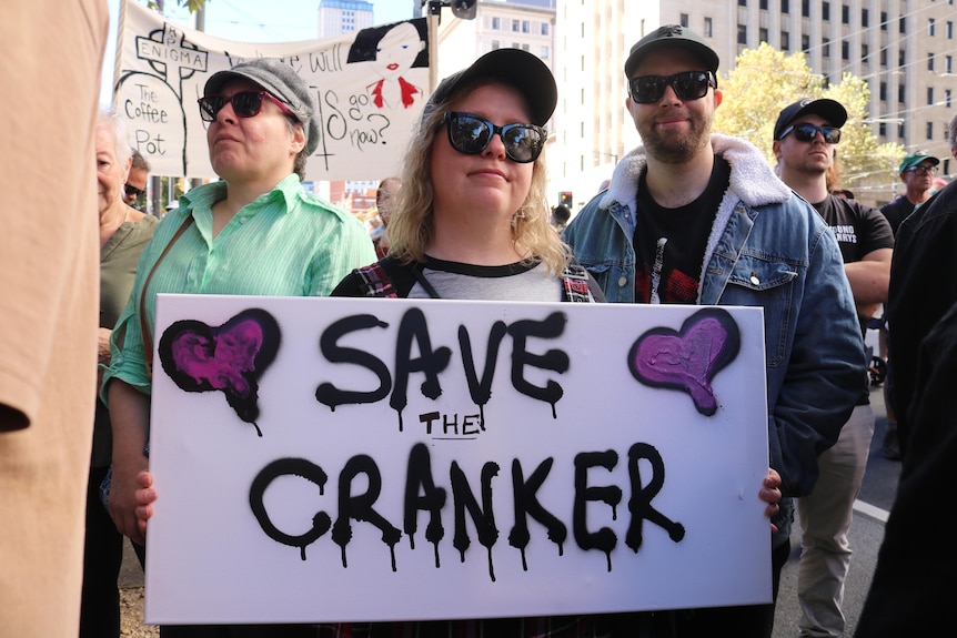 People hold a sign that says 'Save the Cranker'.
