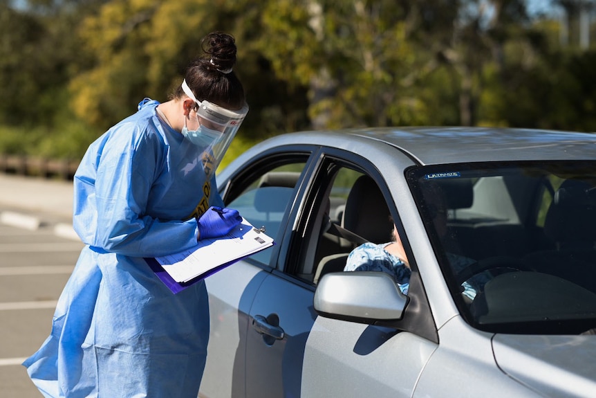 A health worker and a motorist at a COVID drive-through testing site Brisbane.