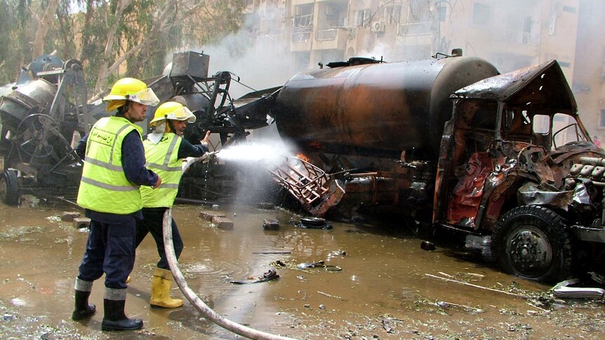 Syrian firefighters douse a burning truck at the site of the blast.