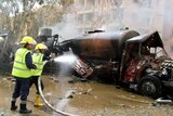 Syrian firefighters douse a burning truck at the site of the blast.