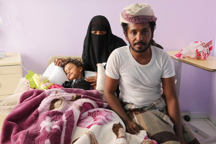 A young girl in bed with her mother and father