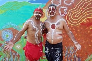 Two Indigenous men in traditional Aboriginal dress are part of the traditional  healing process