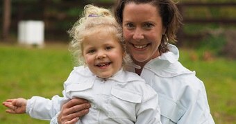 A woman looks at the camera while holding her daughter.