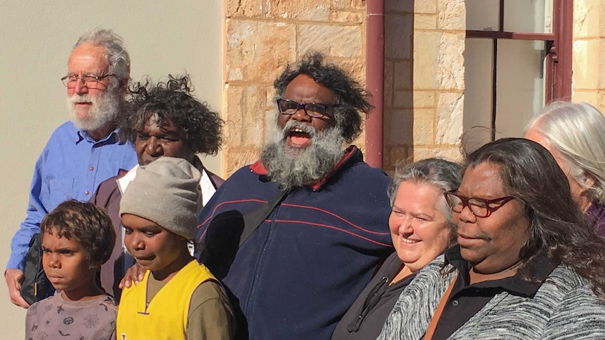 A crowd of people stand out the front of the Kalgoorlie Courthouse after the resolution of a case.