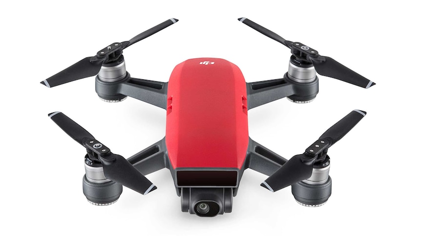 A professional airbrushed photograph of a black and red drone with four against a white background.