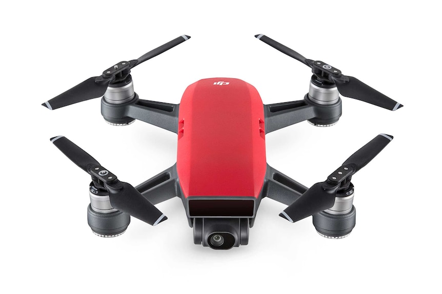 A professional airbrushed photograph of a black and red drone with four against a white background.