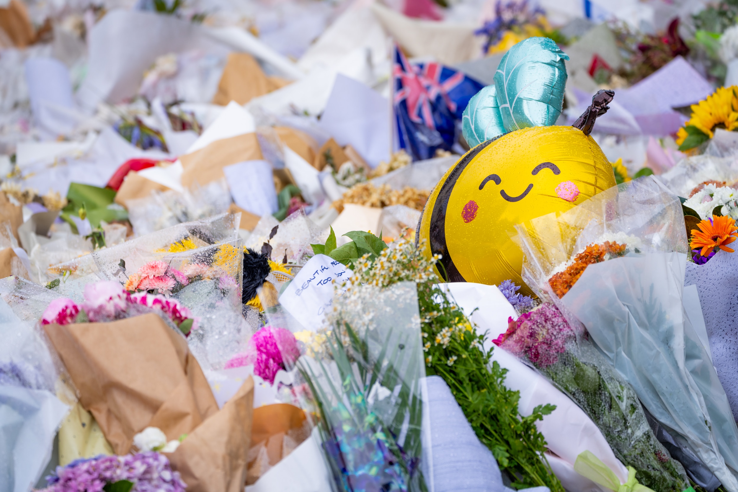 um balão de abelha entre buquês de flores no chão