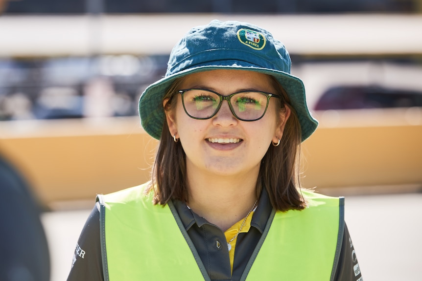 a young woman with glasses smiles at the camera