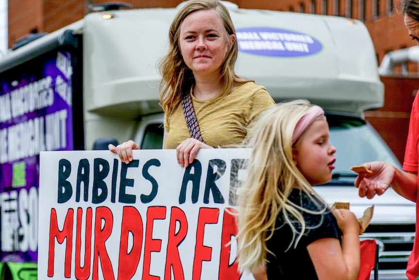 Women holding signs. 