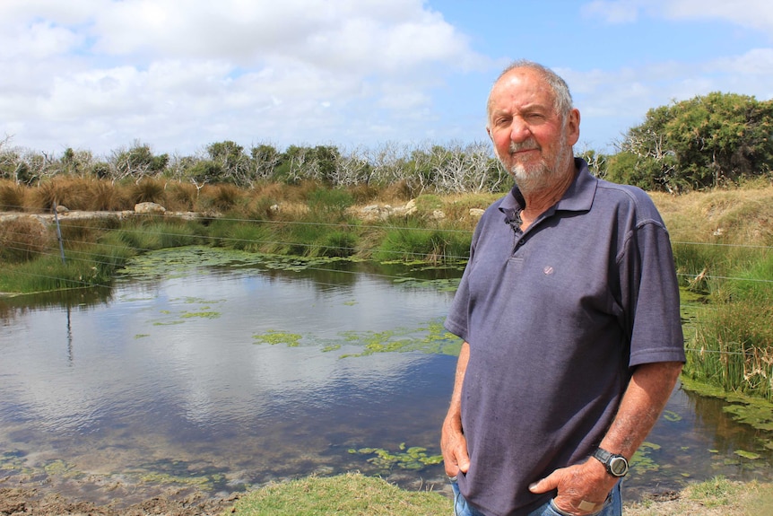 Farmer David Johnson stands next to a local waterway near the proposed rubbish tip site.