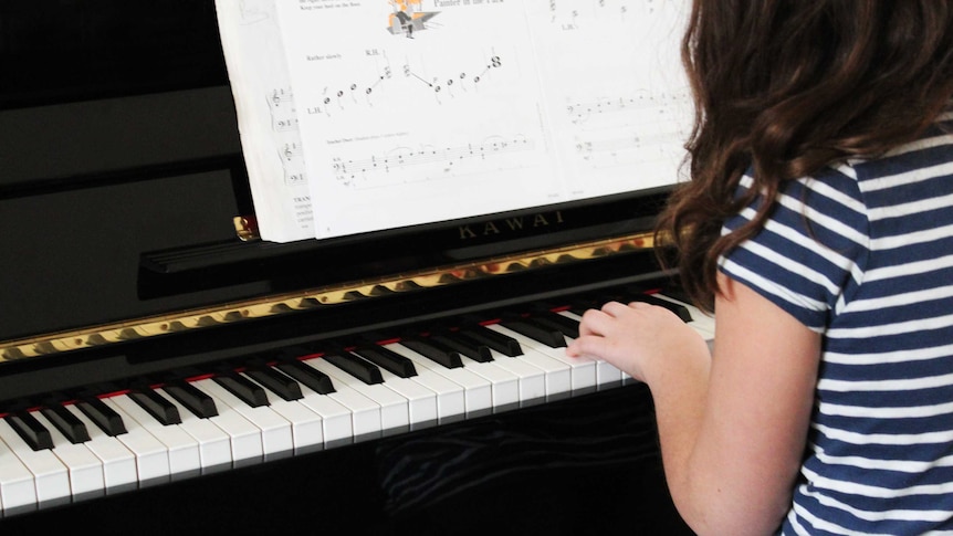 A child practises piano.