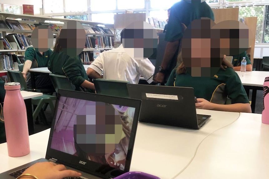 Anonymous students sit together in a library at a state high school during the coronavirus pandemic.