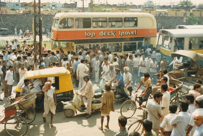 一辆大巴士停在熙熙攘攘的德里大街上