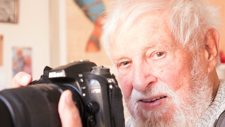 Close-up of Mick Rebbett holding his camera