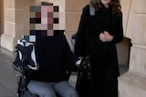 A man in a wheelchair with a pixelated face next to a woman