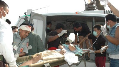 An injured person is carried on to a helicopter in southern Thailand.