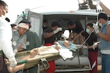 An injured person is carried on to a helicopter in southern Thailand.