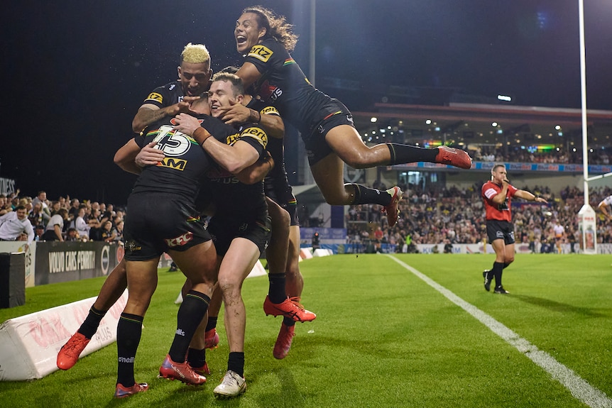 A group of Panthers players jump on each other in celebration