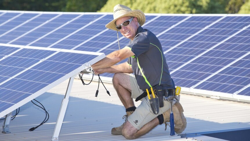 An installer makes final adjustments to one of CORENA's solar installations.