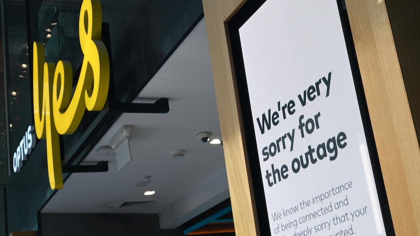 A sign outside the Optus store reads We're very sorry for the outage."