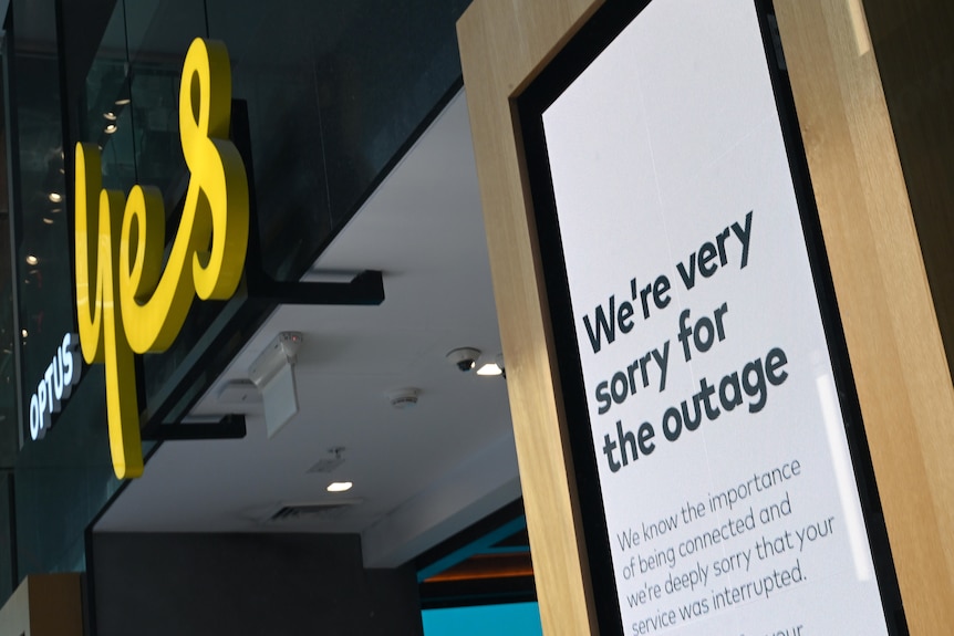 A sign outside the Optus store reads We're very sorry for the outage."