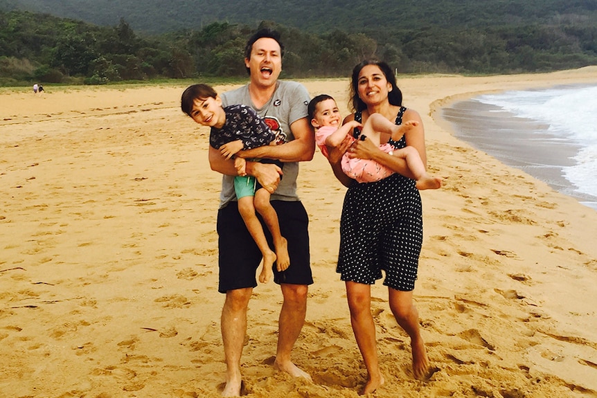 Gavin and Niyati Libotte with their two children on the beach.