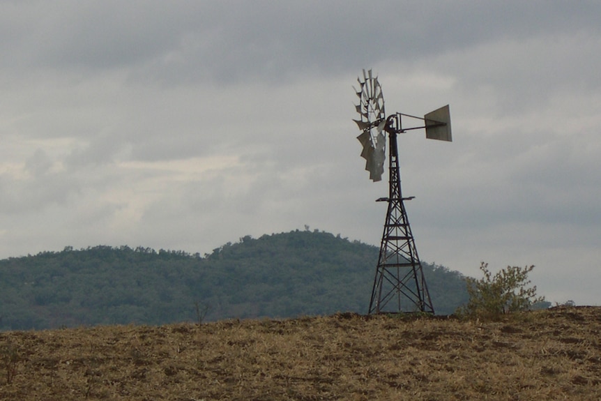 Old style rural windmill and dry grass near Gilgandra NSW. Generic rural scene.