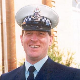 Constable Miller in his police uniform in front of blue background.