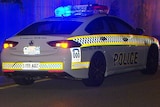 A police car at night with blue lights flashing