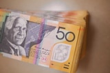Stack of several thousand dollars worth of Australian $50 notes showing David Unaipon