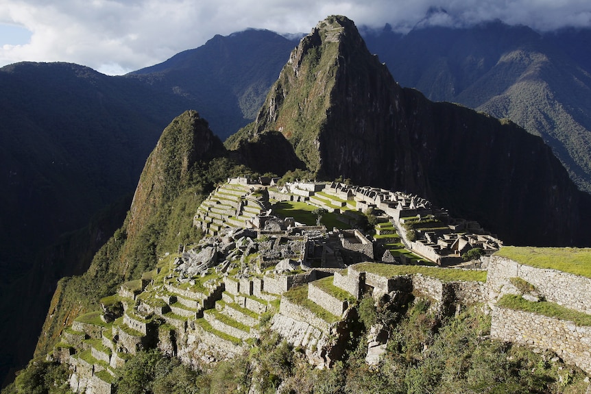 An Incan city sits on the side of a mountain. 