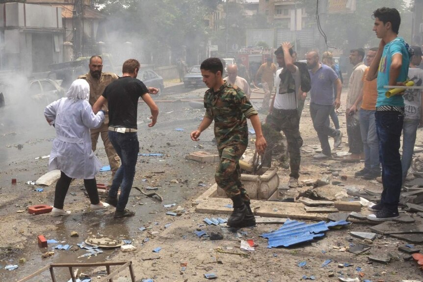 People evacuate the Al-Dabbeet hospital after it is hit by rocket fire.