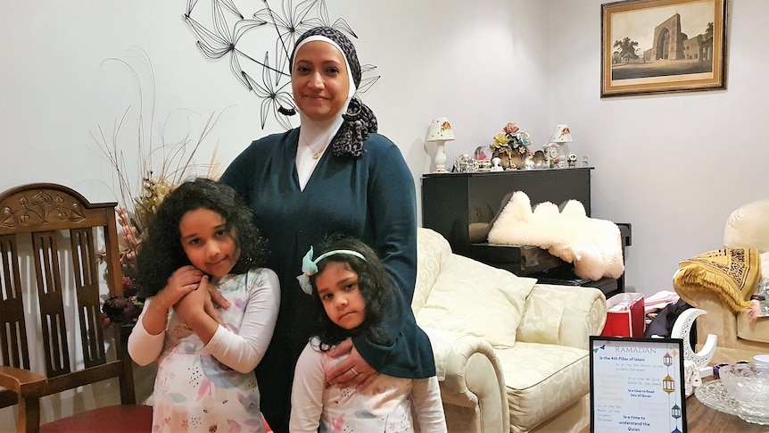 A women with two daughters in a living room .