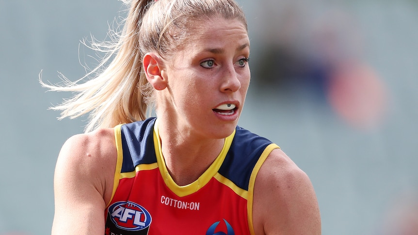 AFLW player with the ball in her hands during a match
