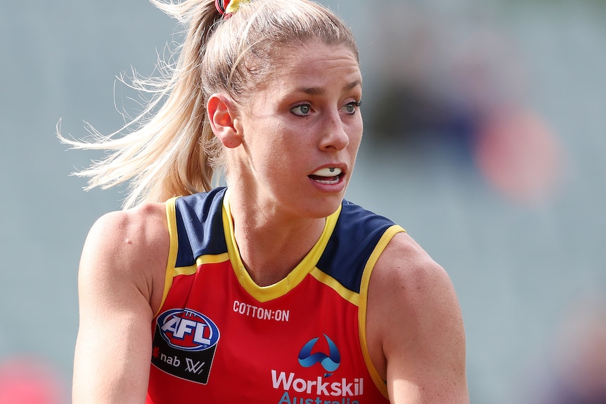 AFLW player with the ball in her hands during a match