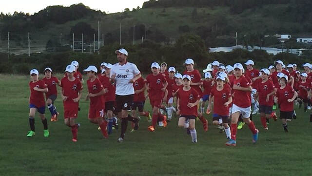 Harry Kewell leads the warm up at Lismore
