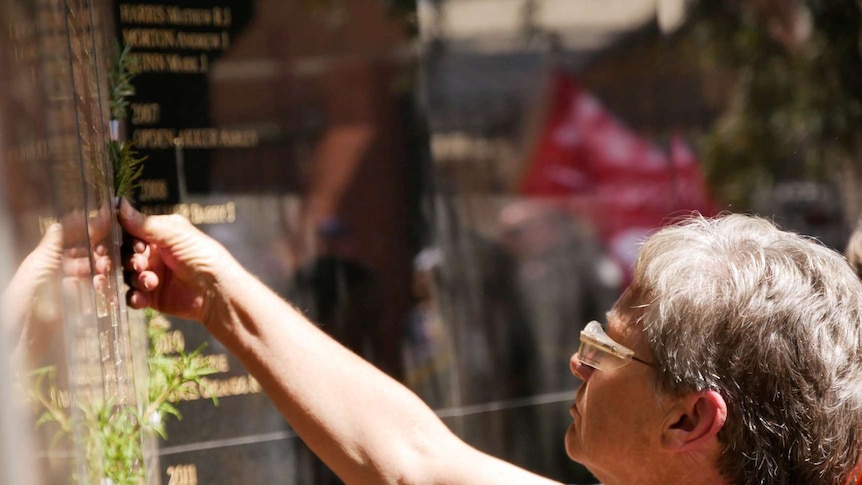 A woman pays her respects at a miners' memorial wall in Kalgoorlie.