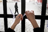 A woman ties a white ribbon to Red Square's Resurrection Gate.