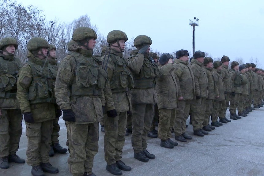 Russian troops in battle fatigues line up on arrival in Belarus