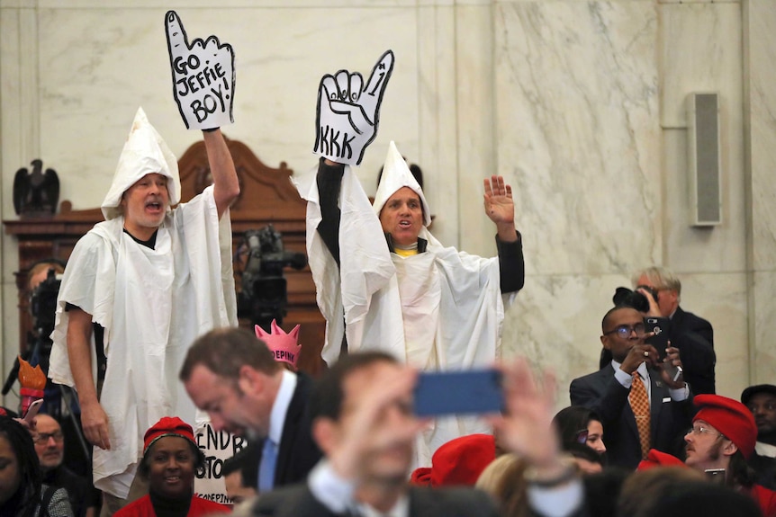 Protesters dressed up in Ku Klux Klan gear protest at Jeff Sessions hearing