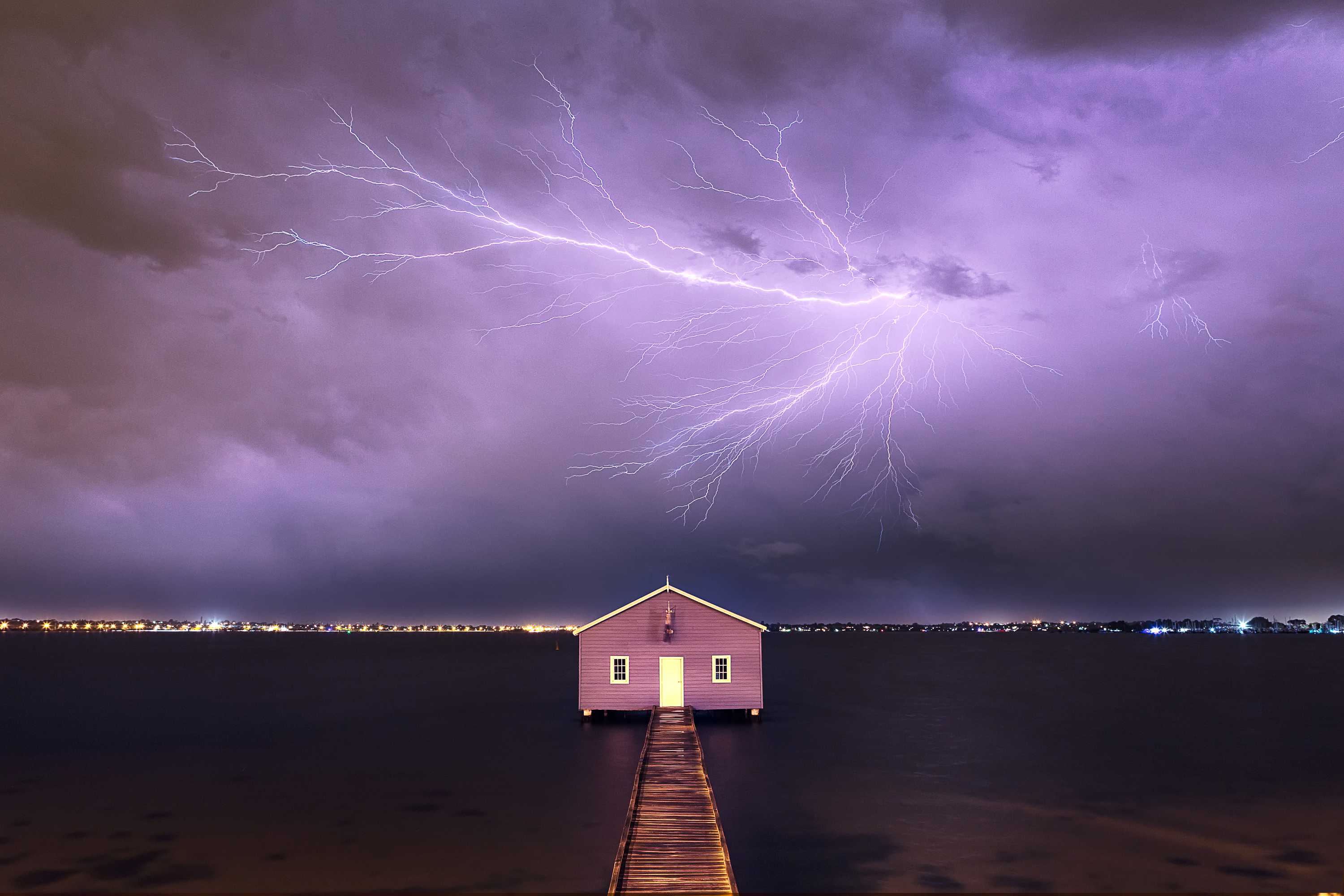 Bolt of lighting across purple coloured stormy sky