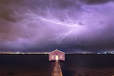 Bolt of lighting across purple coloured stormy sky