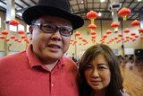 Close-up of Noel and Sandra Ong standing in a hall decorated with Chinese lanterns.
