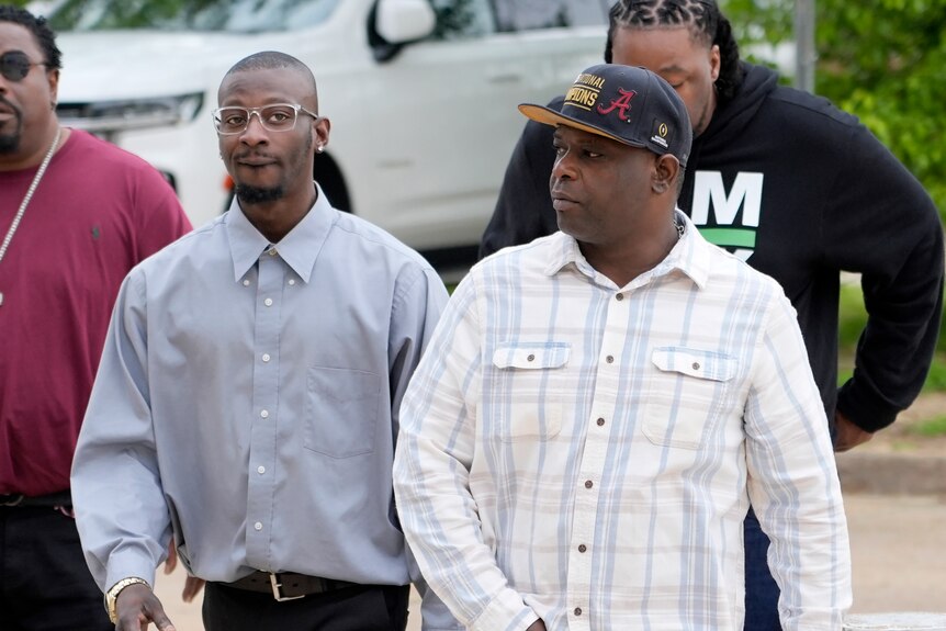 Two Black men walk towards court house