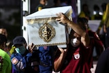 Rescue workers carry a coffin containing the body of a victim.