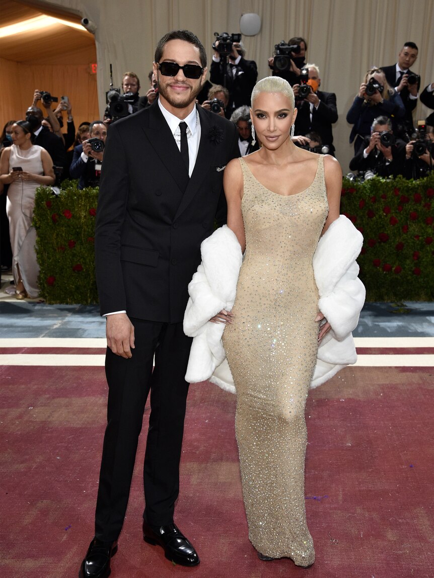 Kim Kardashian wearing a pale blush diamante gown with Pete Davidson in a black suit
