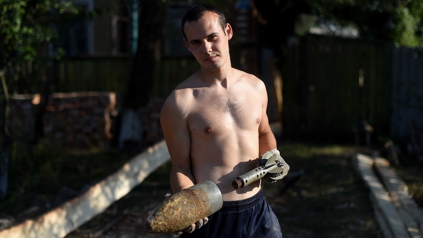 Ukrainian man holds rocket after ceasefire broken