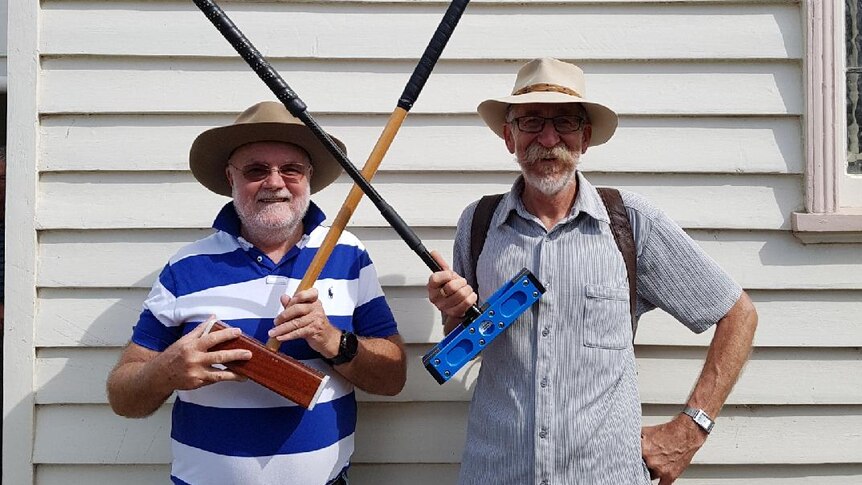 Two croquet members posing with croquet mallets.