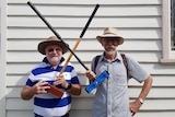 Two croquet members posing with croquet mallets.