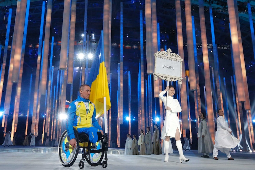 Ukraine's flag-bearer Mykhailo Tkachenko arrives in the Olympic Stadium